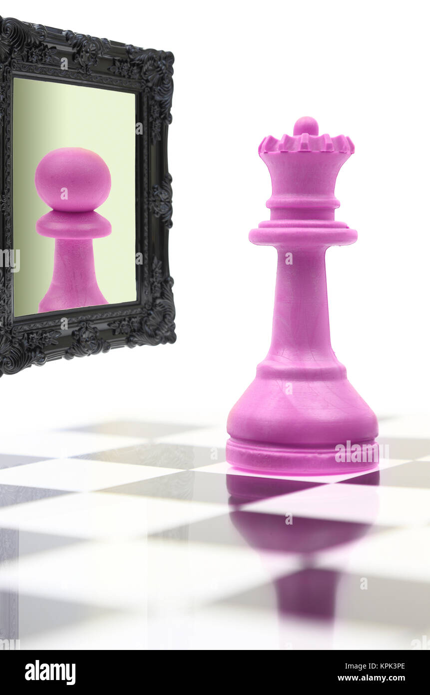 Queen looking in the mirror seeing pawn in reflection Stock Photo