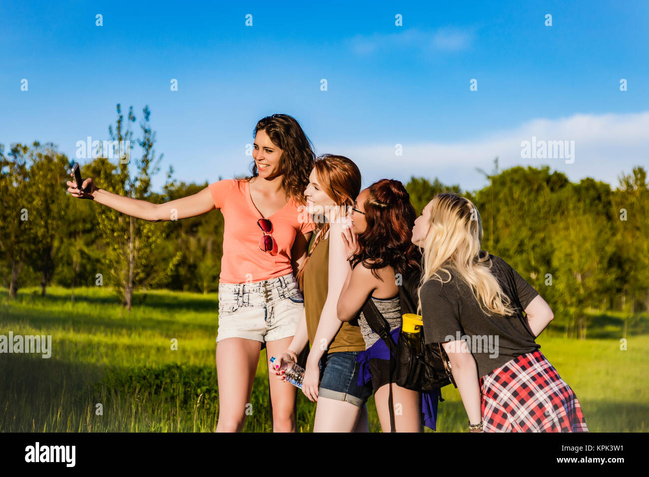 A group of four girlfriends pose for a self-portrait with a smart phone ...