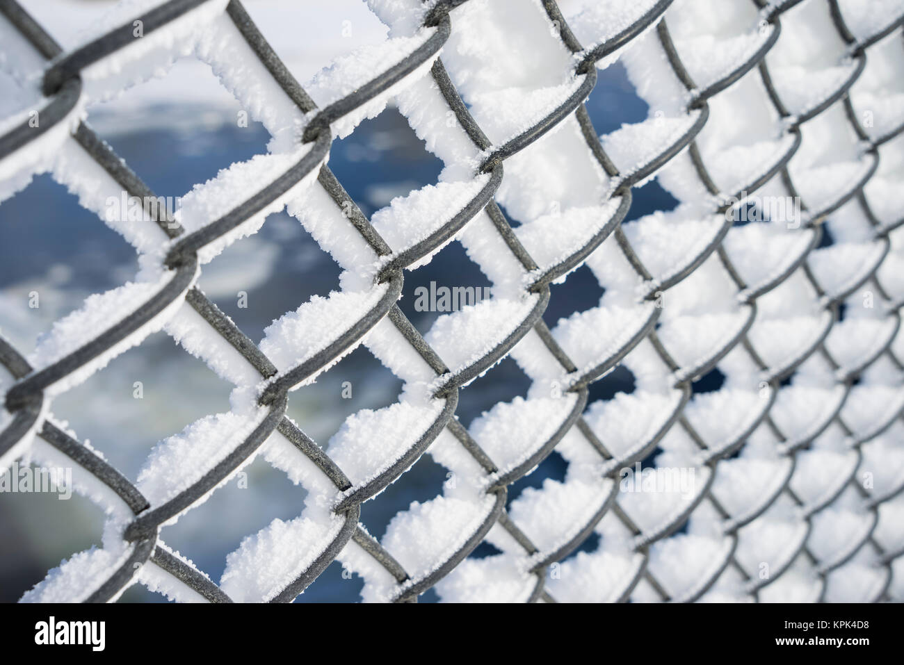 A chain link fence covered in snow and frost; Minnesota, United States of America Stock Photo