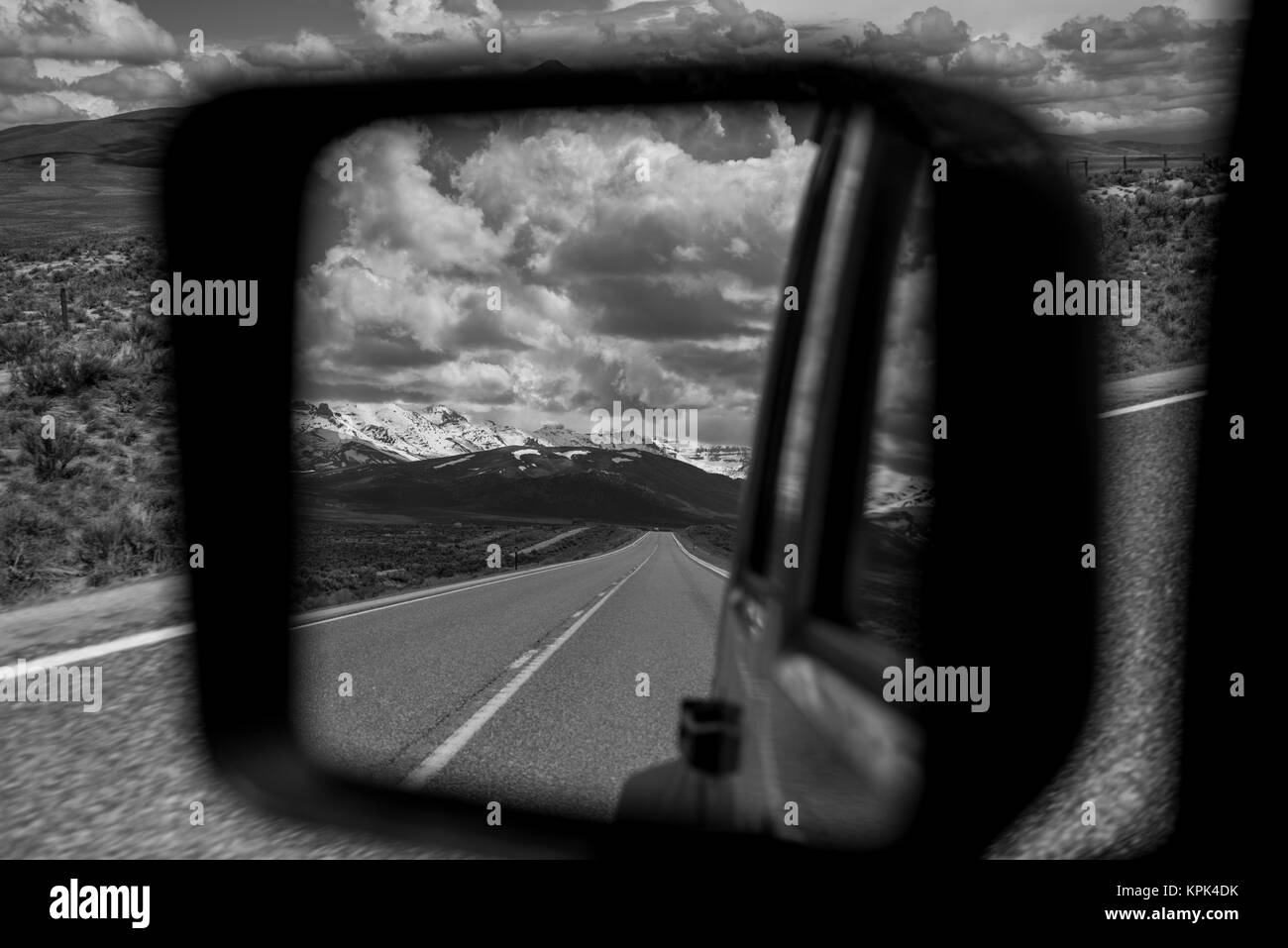 View of the highway and mountains,behind from a vehicle's rear view ...