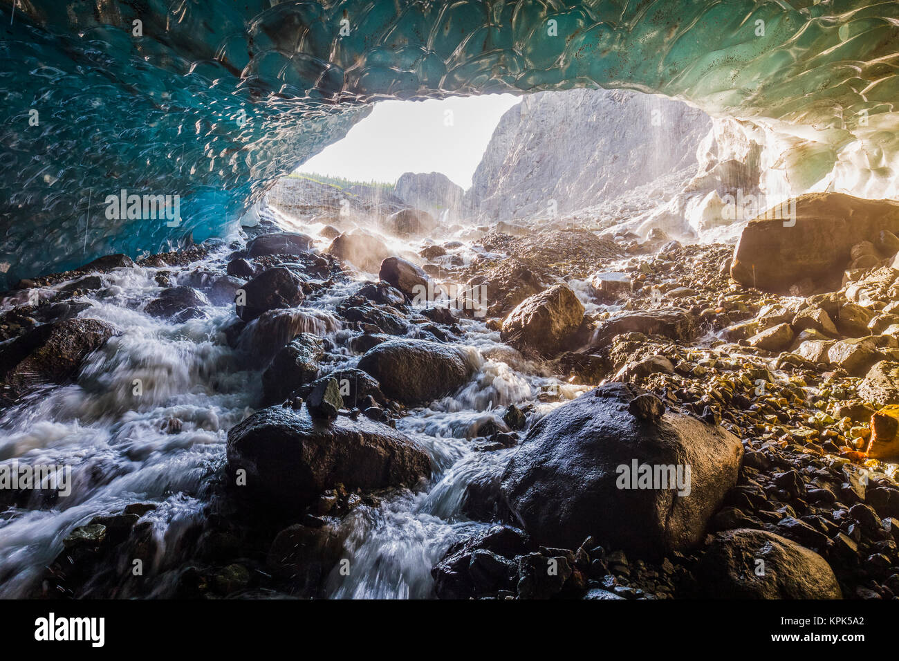Water cascades over rocks inside a cave beneath the ice of Root Glacier in Wrangell-St. Elias National Park; Alaska, United States of America Stock Photo
