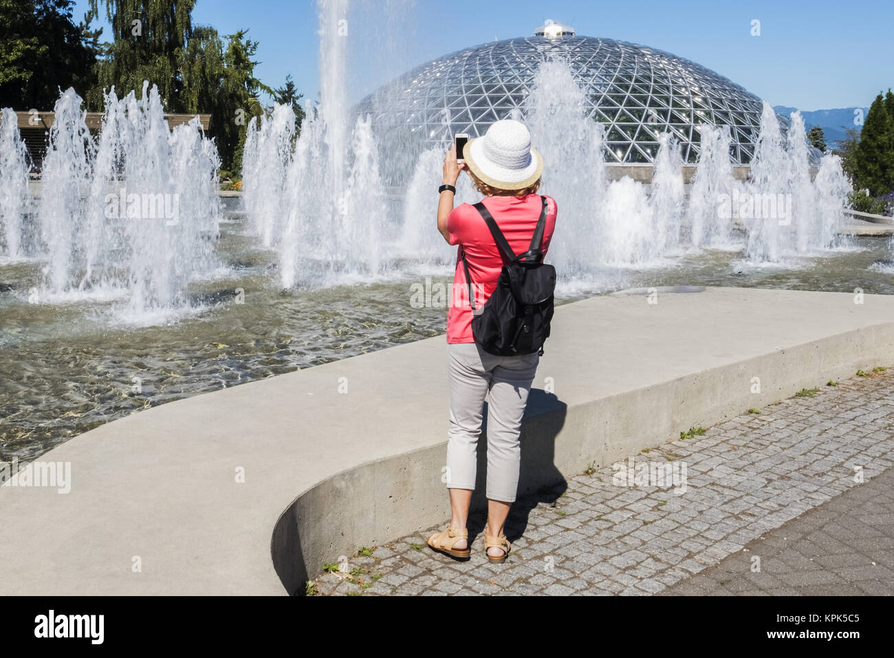 A female tourist takes a photo at Queen Elizabeth Park; Vancouver, British Columbia, Canada Stock Photo