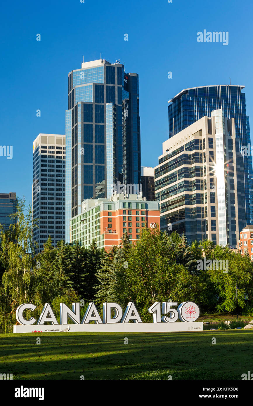 Canada 150 signage in city park with Calgary building towers in