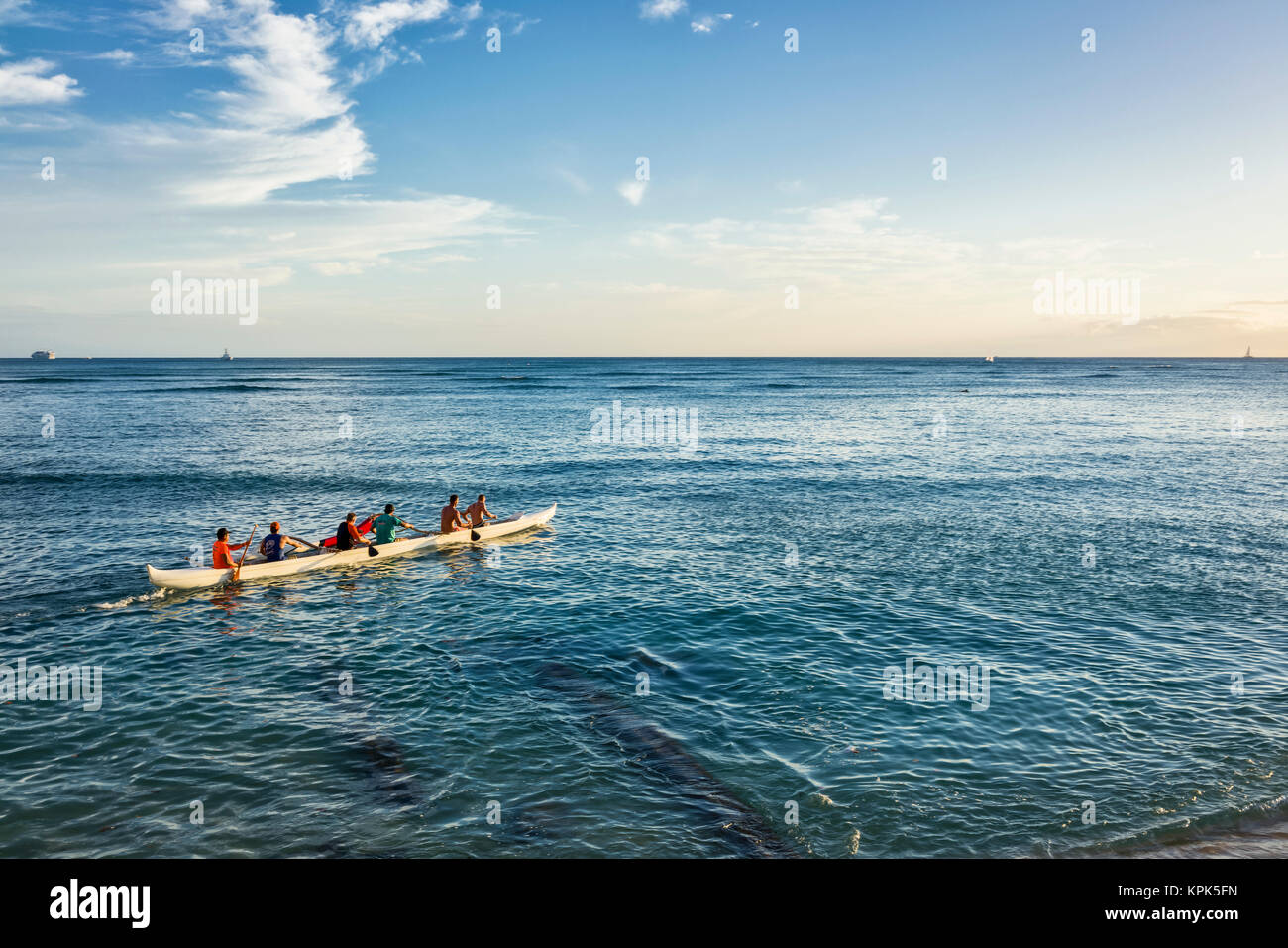 Tourists paddle in an outrigger canoe off Waikiki Beach; Waikiki, Oahu