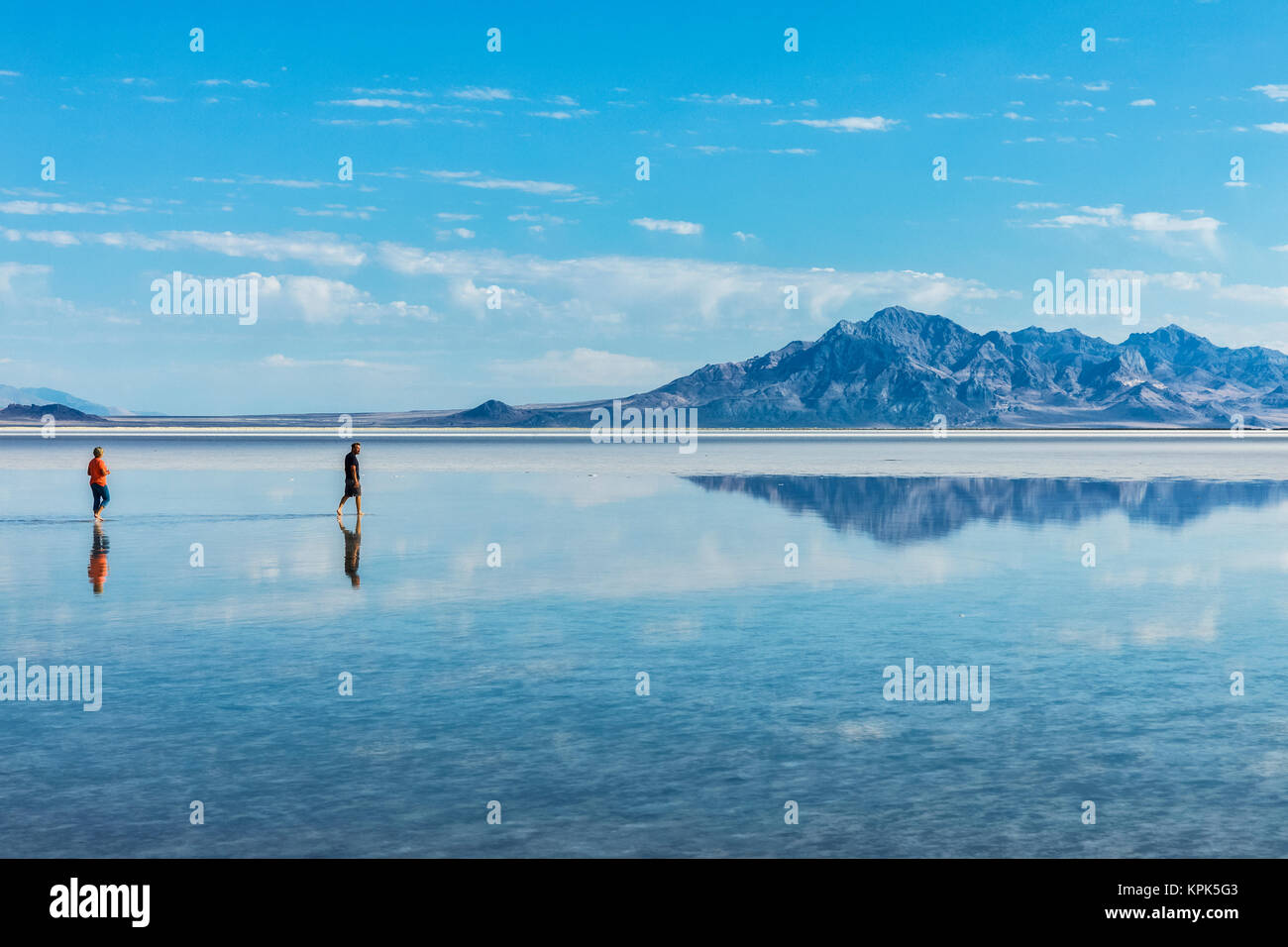 Tourists walk in inches deep salt water near Bonneville Salt Flats