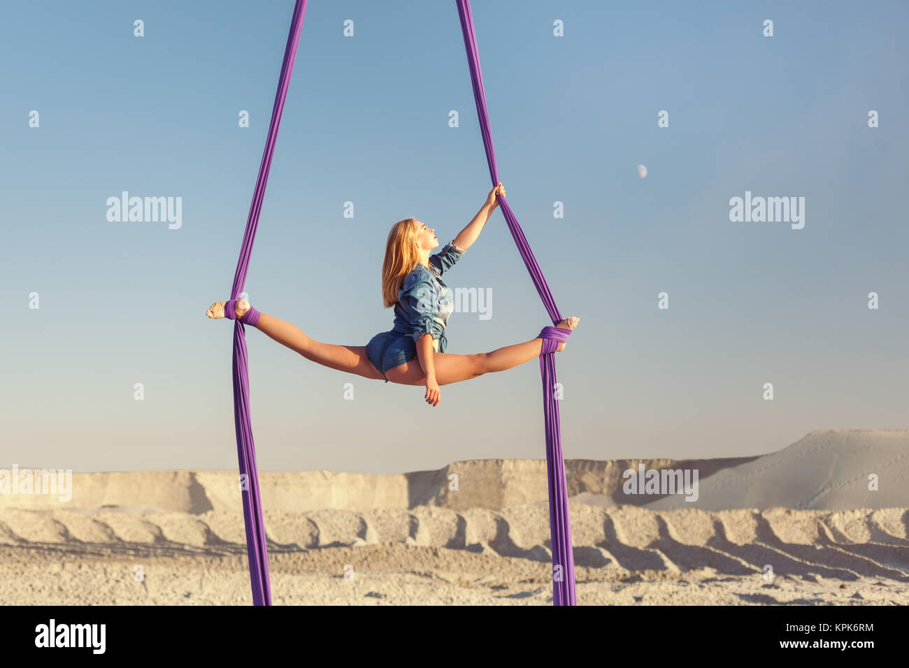 Woman is an air acrobat on canvases, in the desert high above the earth. Stock Photo