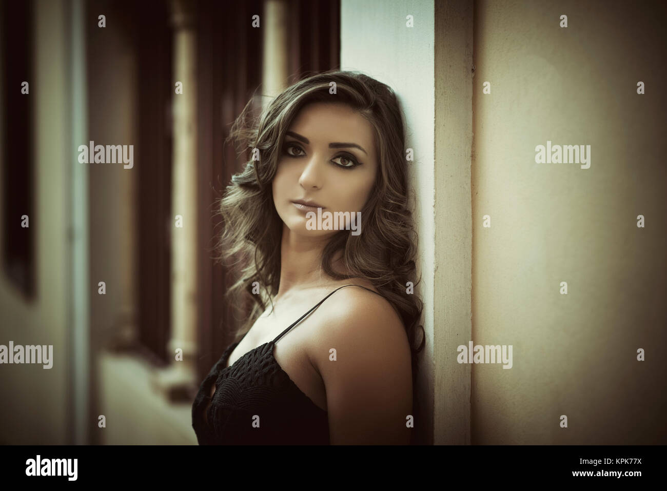 Beautiful young woman leaning against the wall outdoors Stock Photo - Alamy