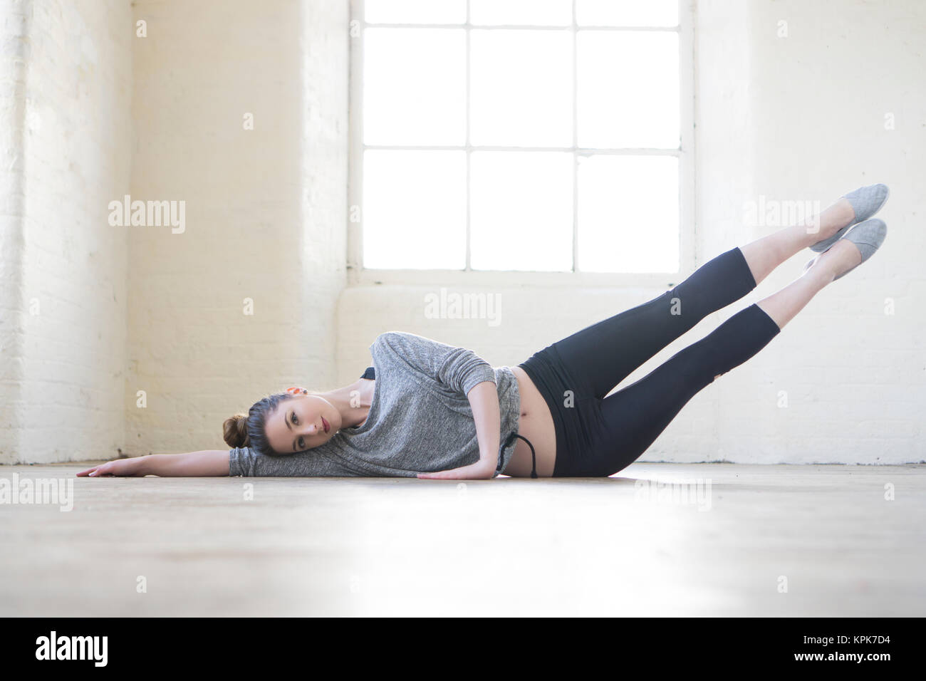 Healthy young woman stretching on the floor Stock Photo - Alamy