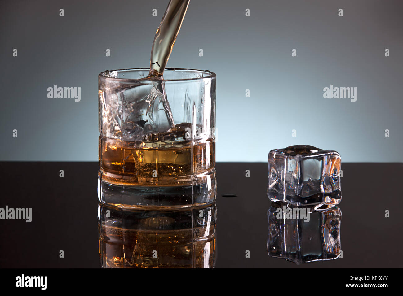 A studio image of a glass filled with ice and liquor. Stock Photo