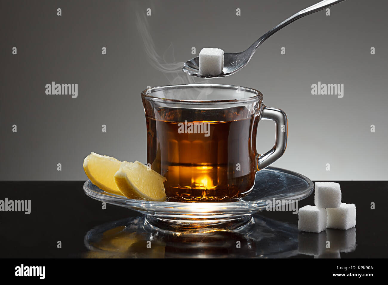 Putting a sugar cube into a cup of hot tea Stock Photo - Alamy, image size:1300x956