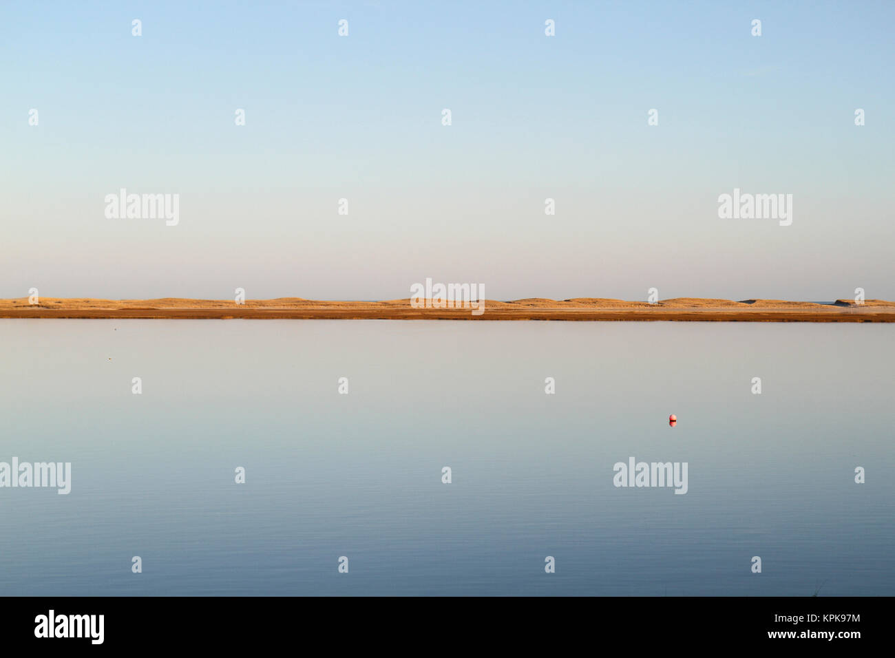 View over tranquil waters towards dunes on Cape Cod, Massachusetts, USA Stock Photo