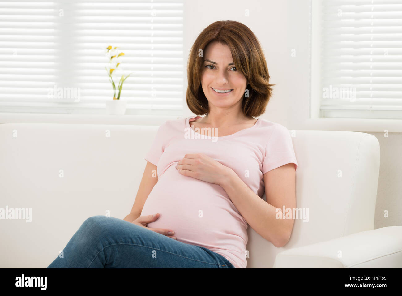 Pregnant Woman Sitting On Sofa Stock Photo Alamy