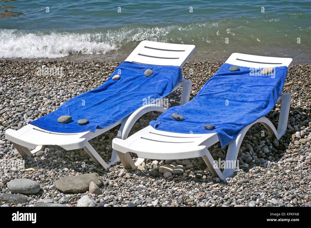 Two sun loungers for relaxing by the sea. Stock Photo