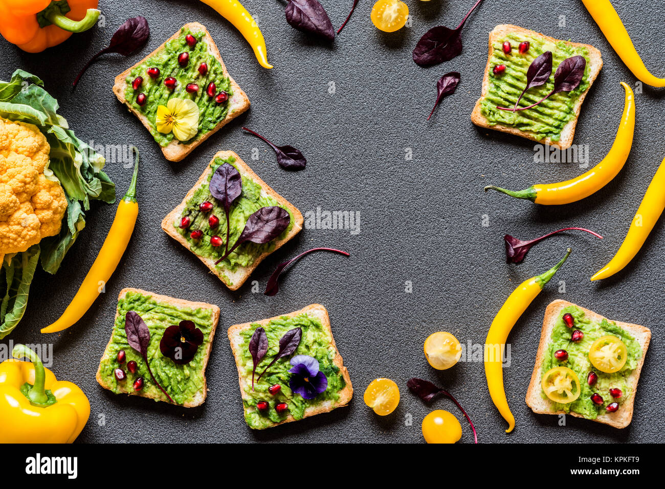 Breakfast different avocado sandwich. Different Fresh colorful organic vegetables. healthy raw vegan food on grey background. Stock Photo