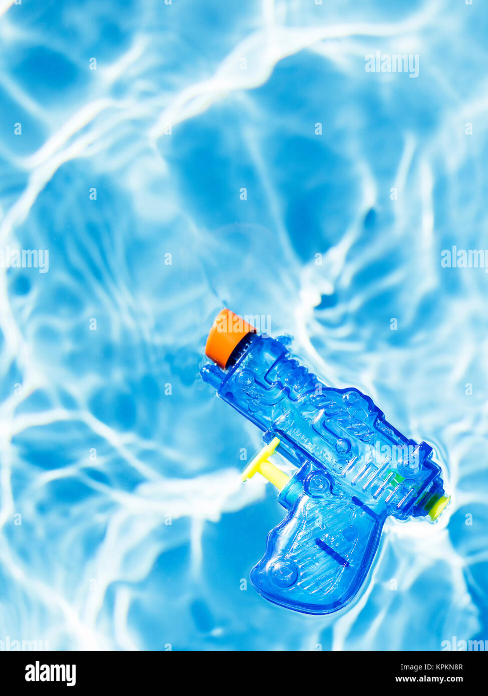 Blue squirt gun floating one water. Stock Photo