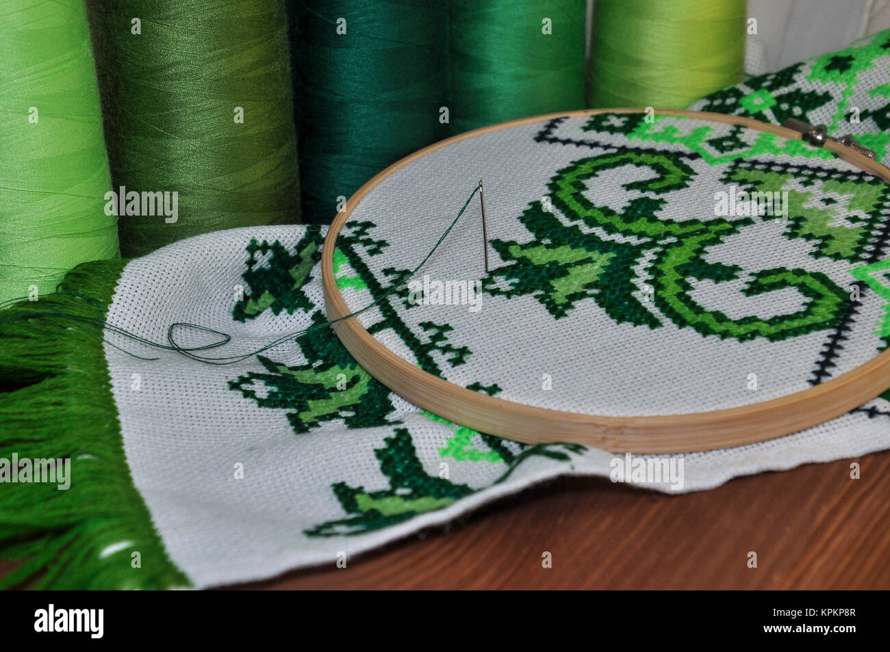 The embroidery hoop with canvas and bright sewing threads for embroidery in the table Stock Photo