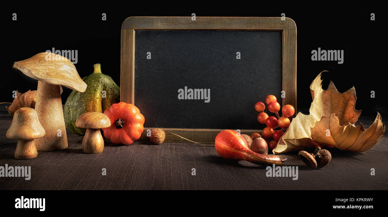 Autumn still life on black background with dry leaves, pumpkins and ...