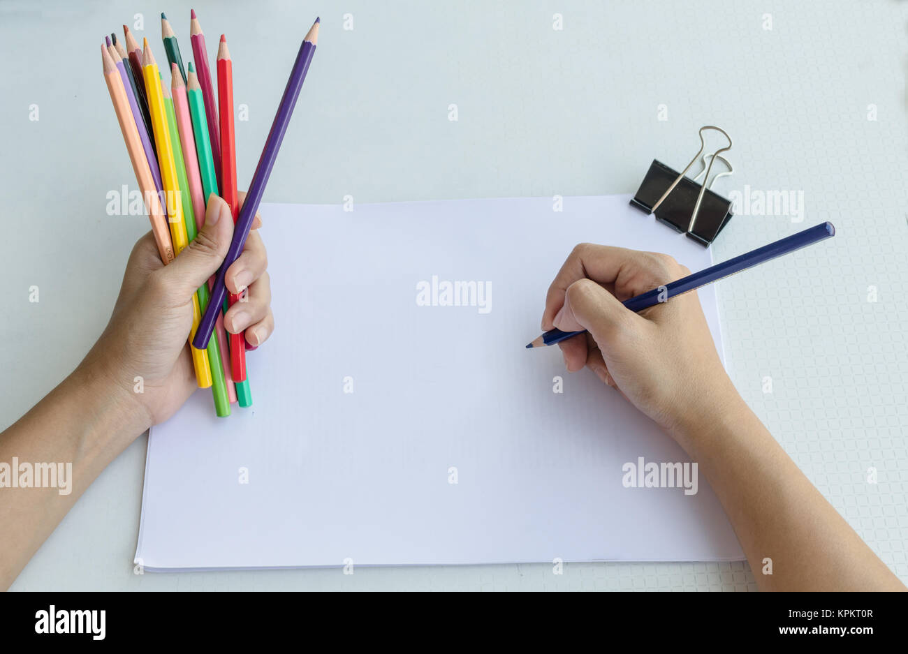 Man commencing sketching in a sketch book to show off his creativity and artistic skills with the other, view from above Stock Photo