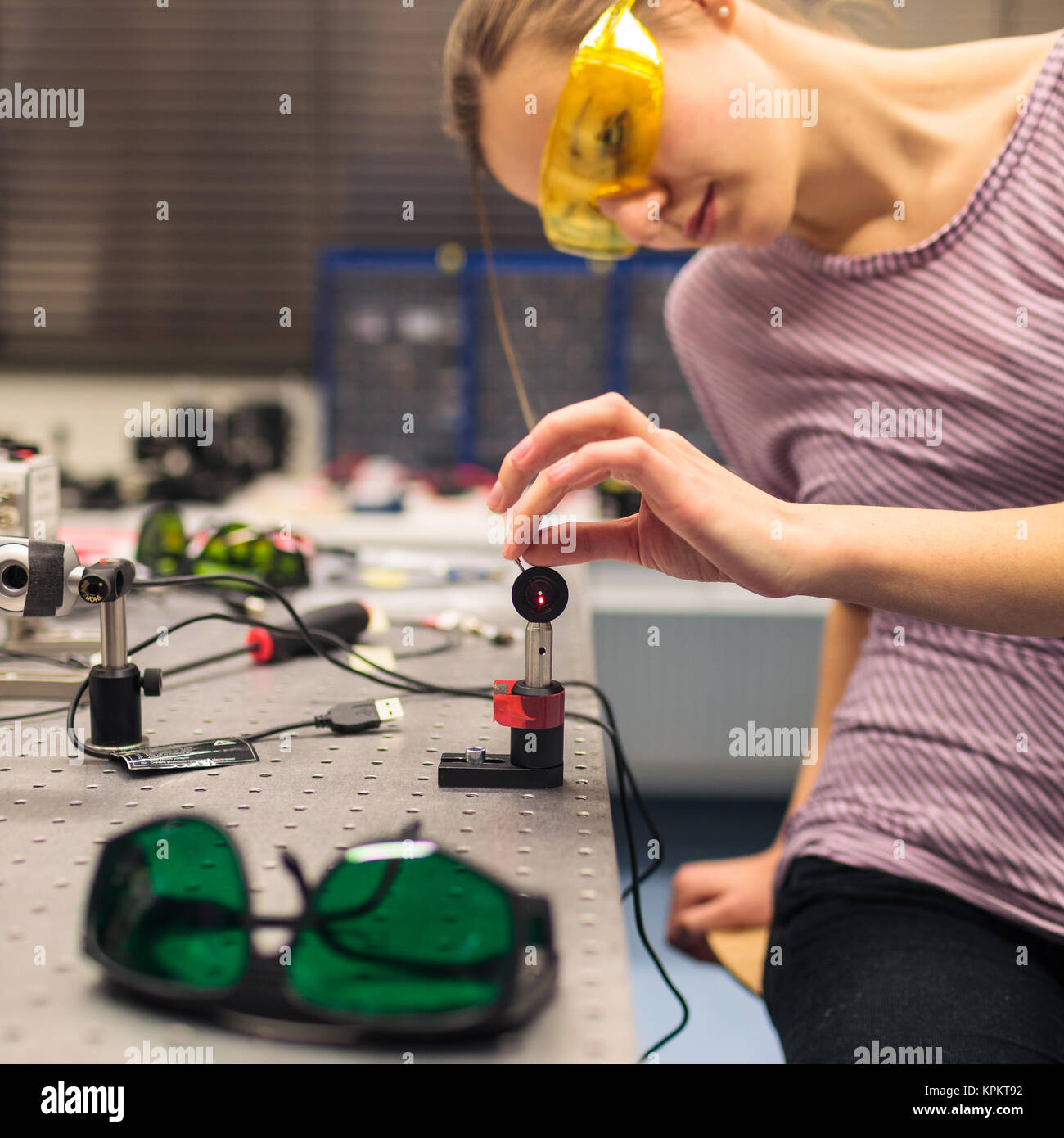 Female scientist carrying out research experiments in a quantum optics lab (color toned image) Stock Photo