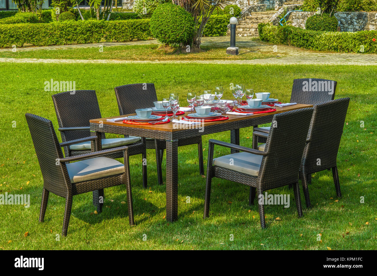 Rattan garden table and chairs with water resistant outdoor cushions