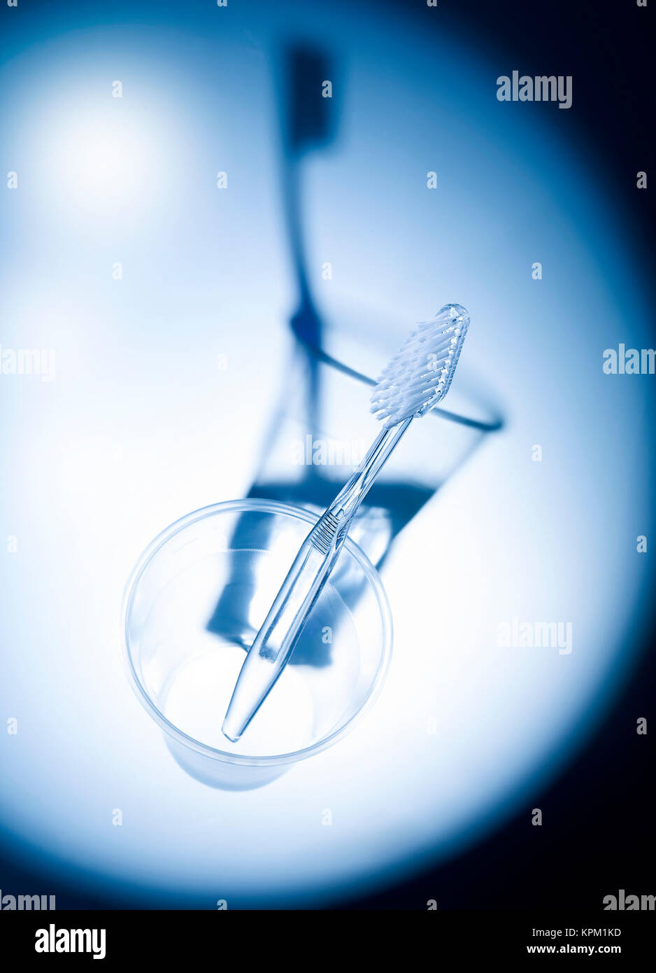 transparent toothbrush in plastic cup in spotlight Stock Photo - Alamy