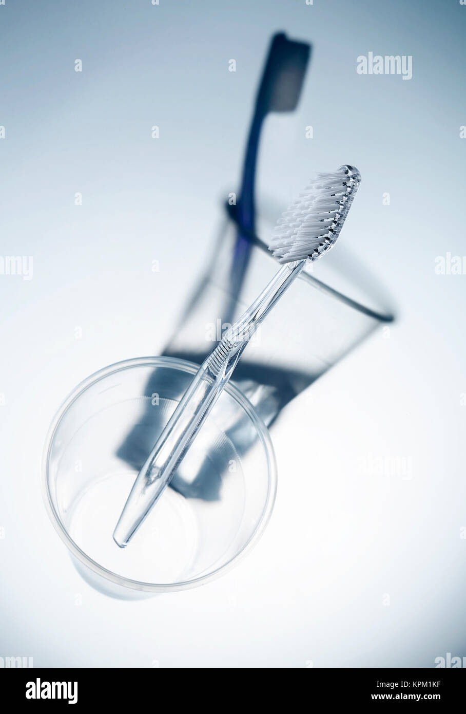 transparent toothbrush in plastic cup with false shadow Stock Photo - Alamy