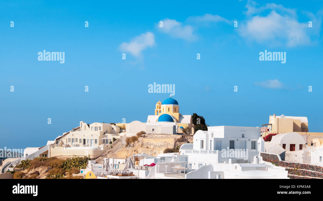 Travel background, with white houses and St George Church in Oia village on Santorini island, Greece. Panoramic background image with text space on th Stock Photo