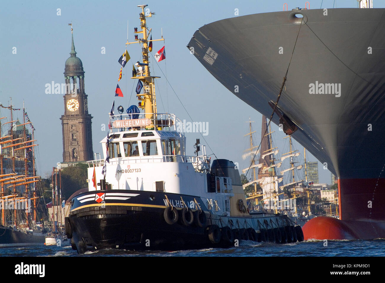 Hamburg, one of the most beautiful and most popular tourist destinations in the world. A harbor tug pulls an ocean liner through the harbor. Stock Photo