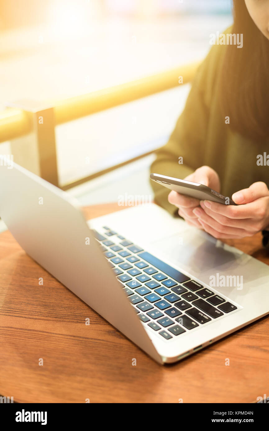 Woman use of mobile phone and laptop computer Stock Photo - Alamy