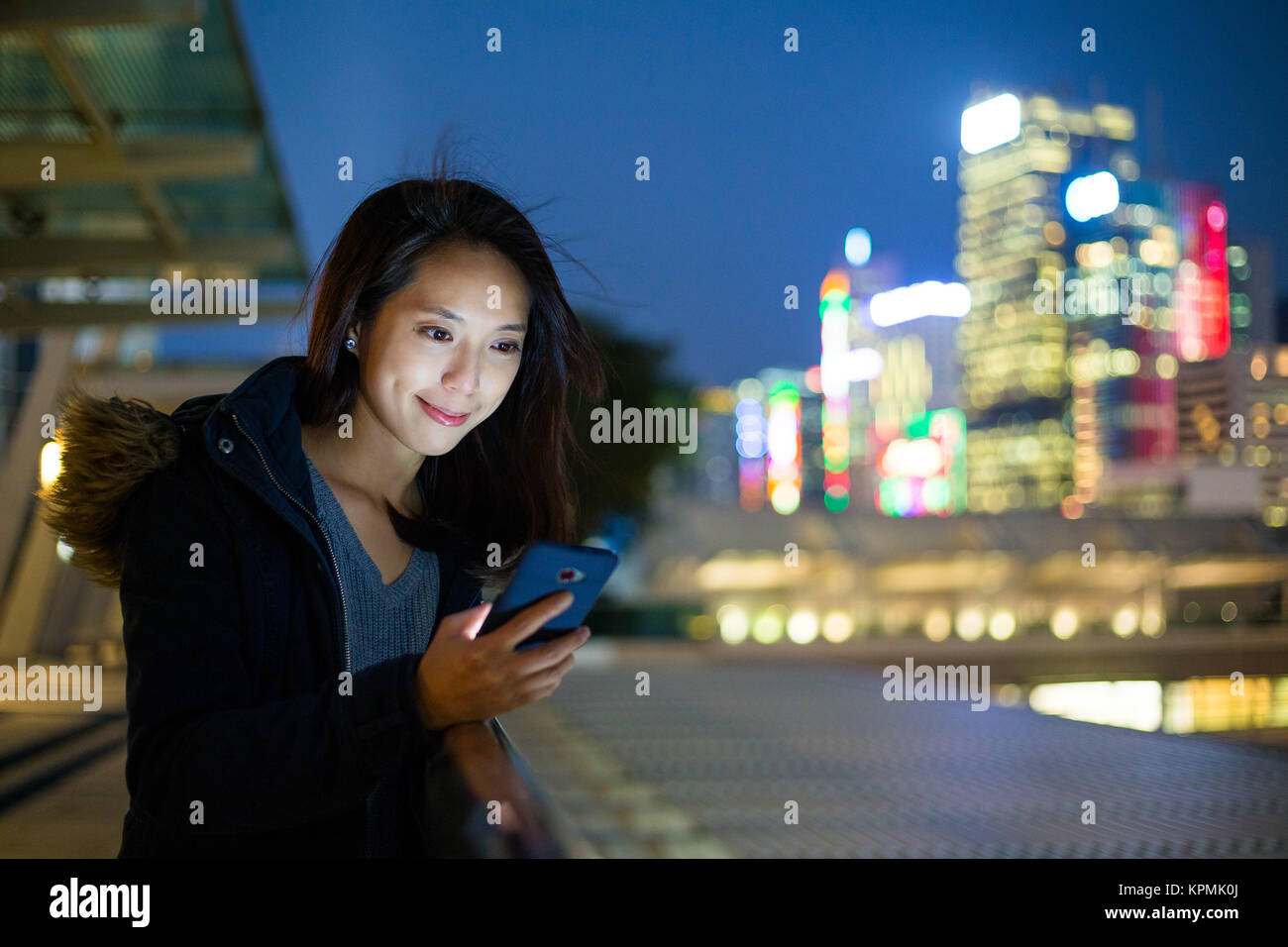 Young woman look at cellphone in Hong Kong Stock Photo - Alamy