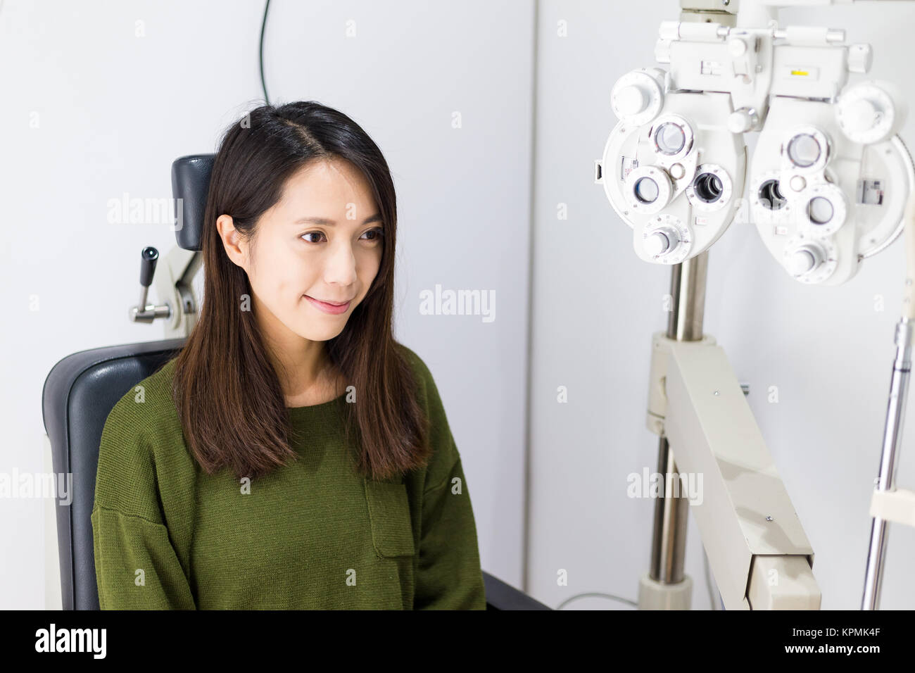 Optician in surgery giving woman eye test Stock Photo