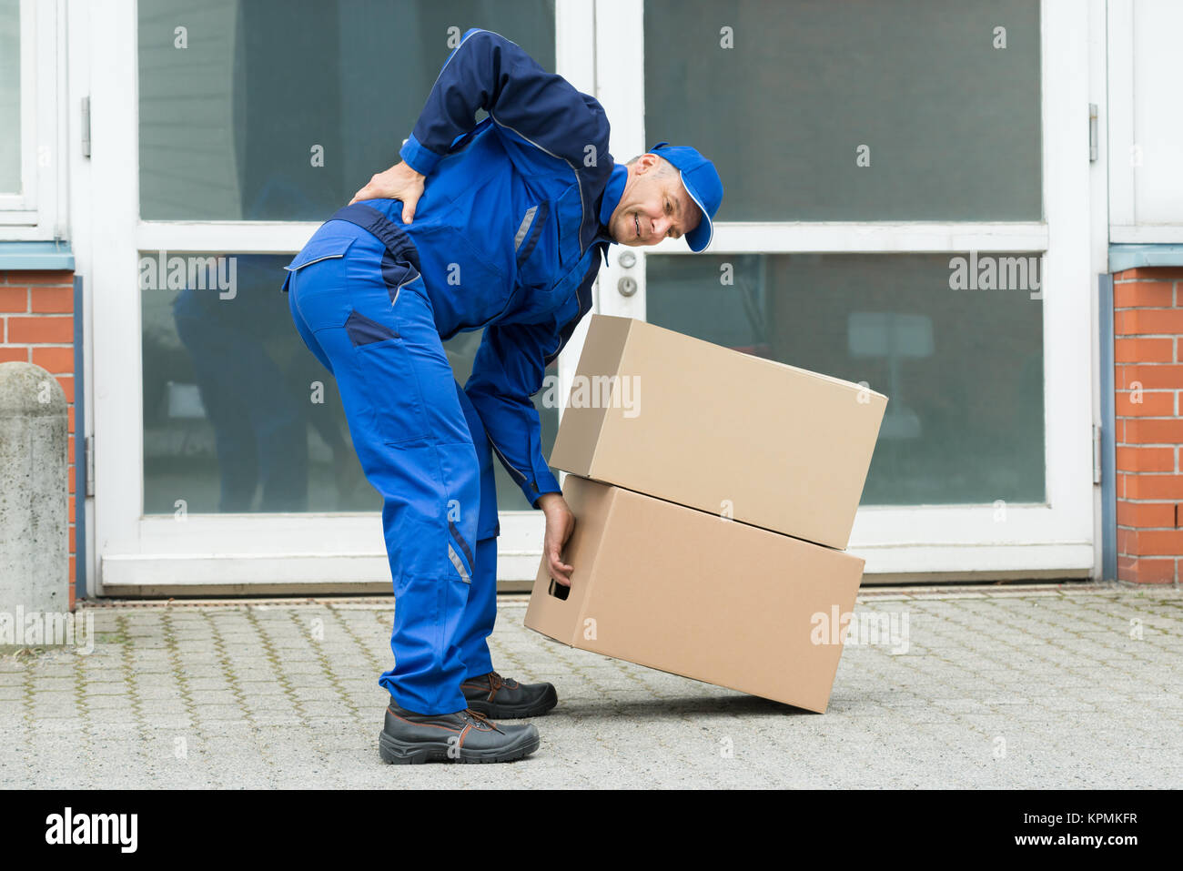Delivery Man Suffering From Backpain Stock Photo