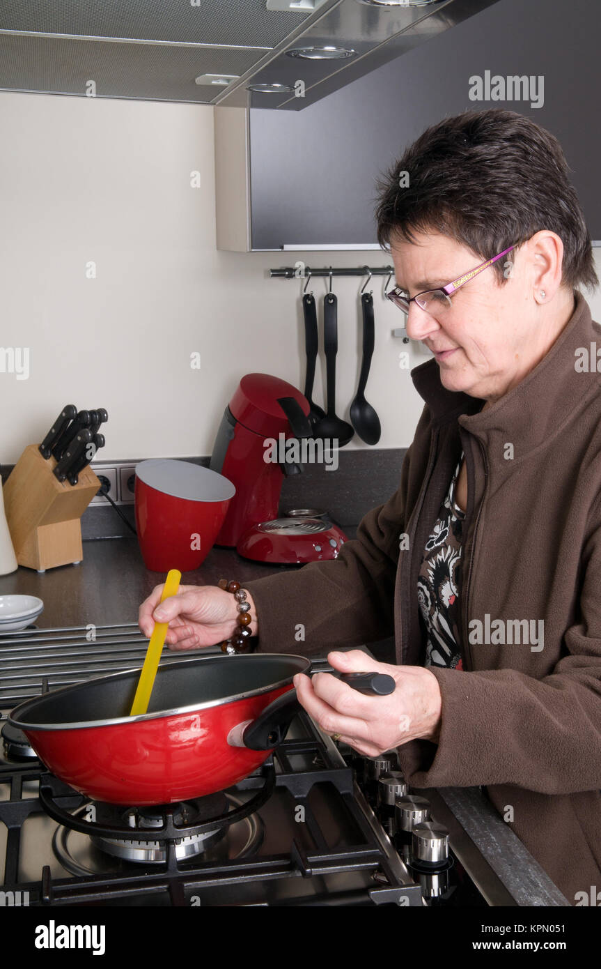 Elderly woman cooking home stirring hi-res stock photography and images ...