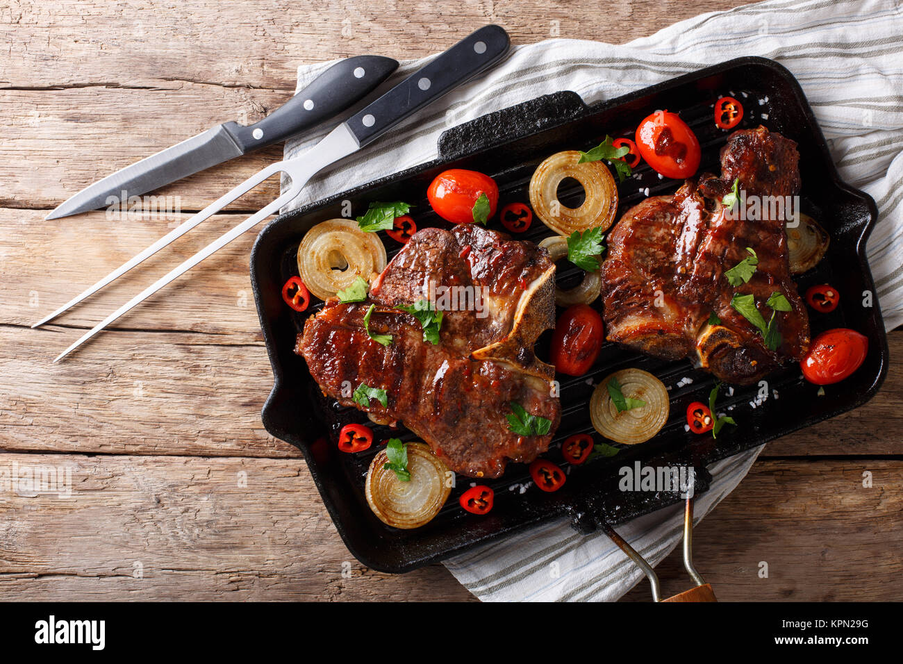 Delicious T Bone steak with grilled vegetables on the grill pan closeup on the table