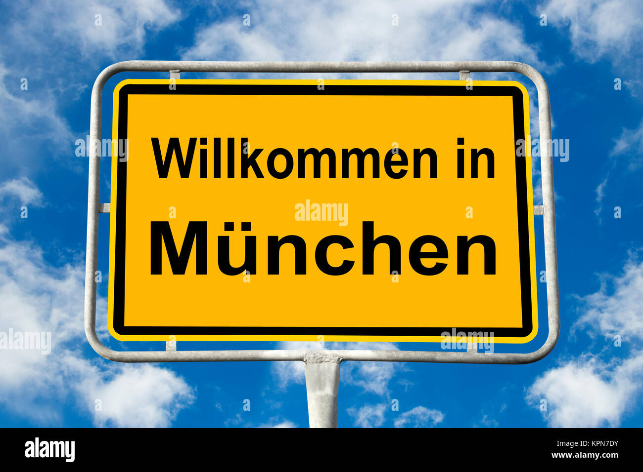 Yellow signpost to Munich in front of blue sky with clouds