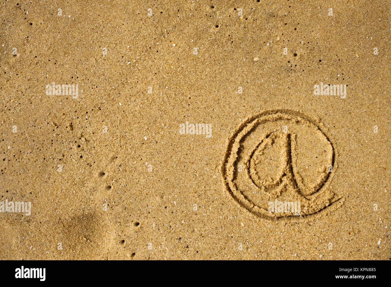 Mail Icon drawn on sea shore sand. Stock Photo