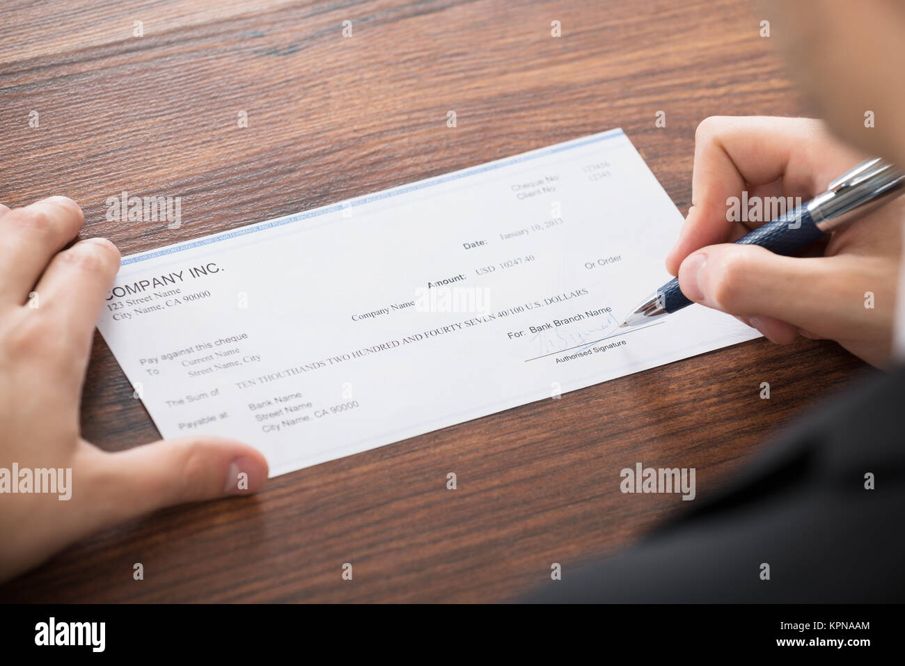Businessman Filling Blank Cheque Stock Photo - Alamy