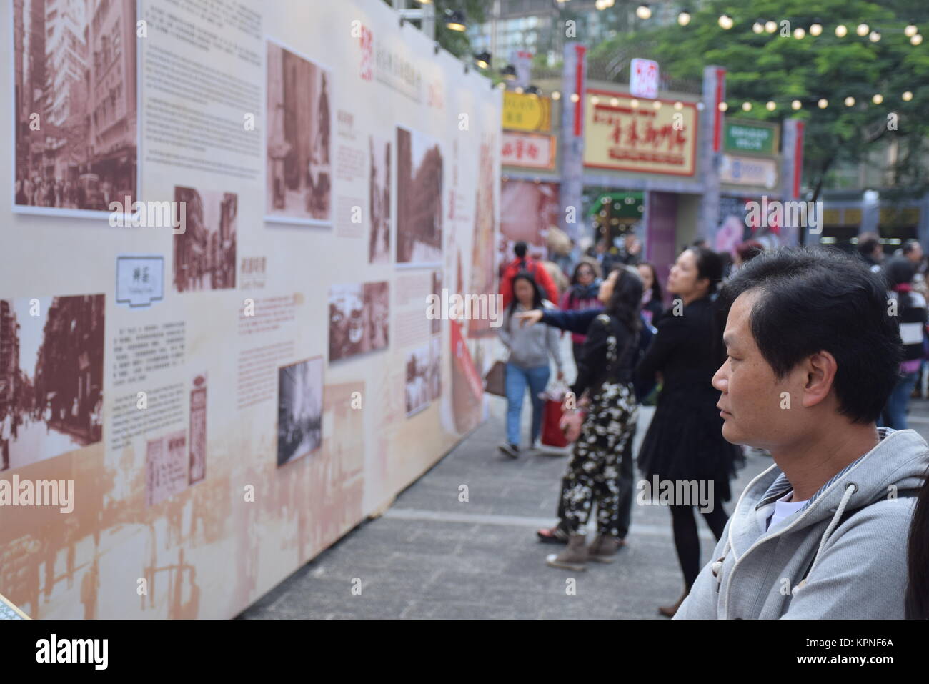 Chinese man reads a panel with information about Chaozhou history in Chiu Chow market in Hong Kong Stock Photo