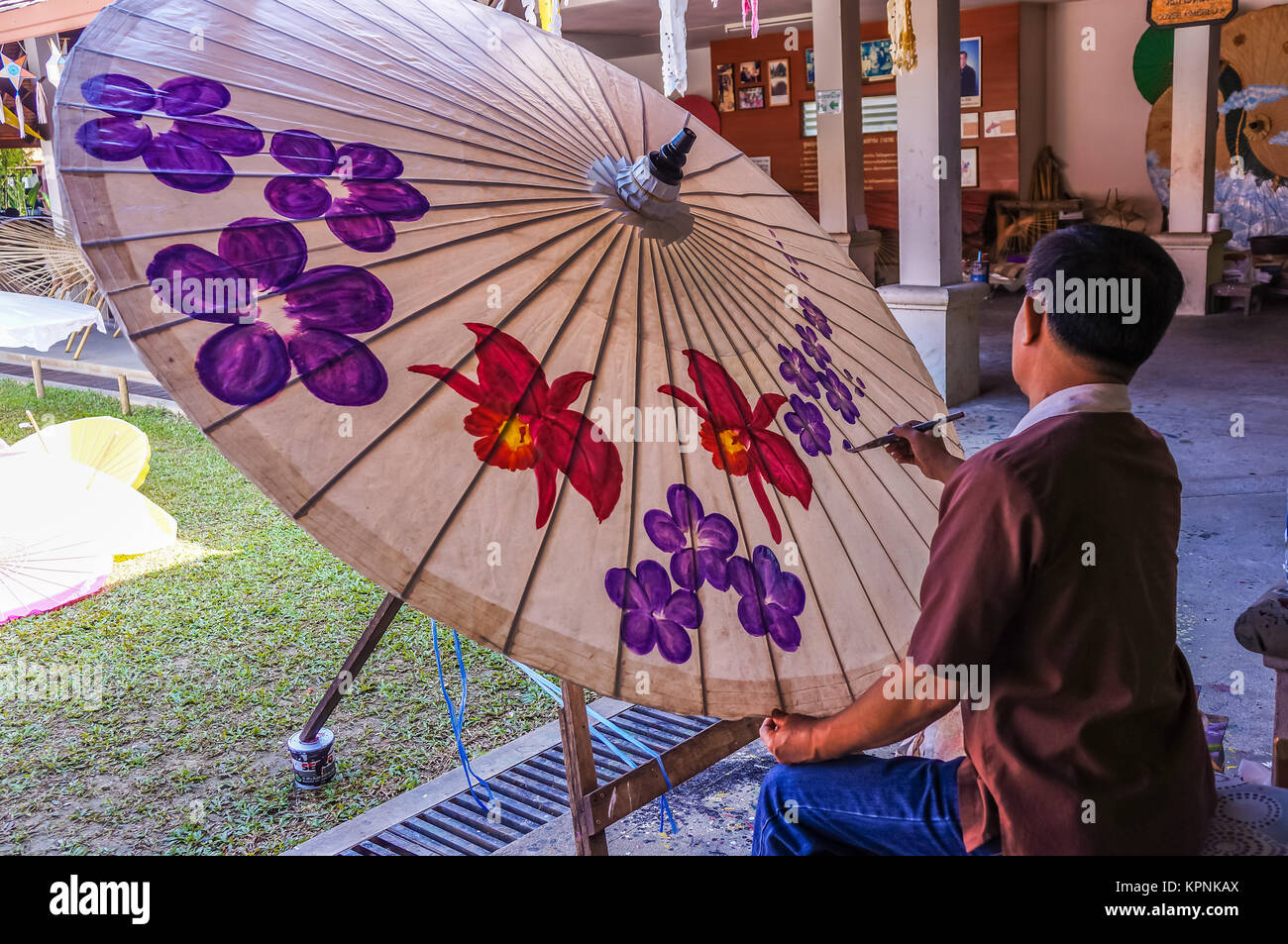 CHIANGMAI, THAILAND - DECEMBER 25, 2013: Man paints flowers on umbrella in Chiangmai, Thailand Stock Photo