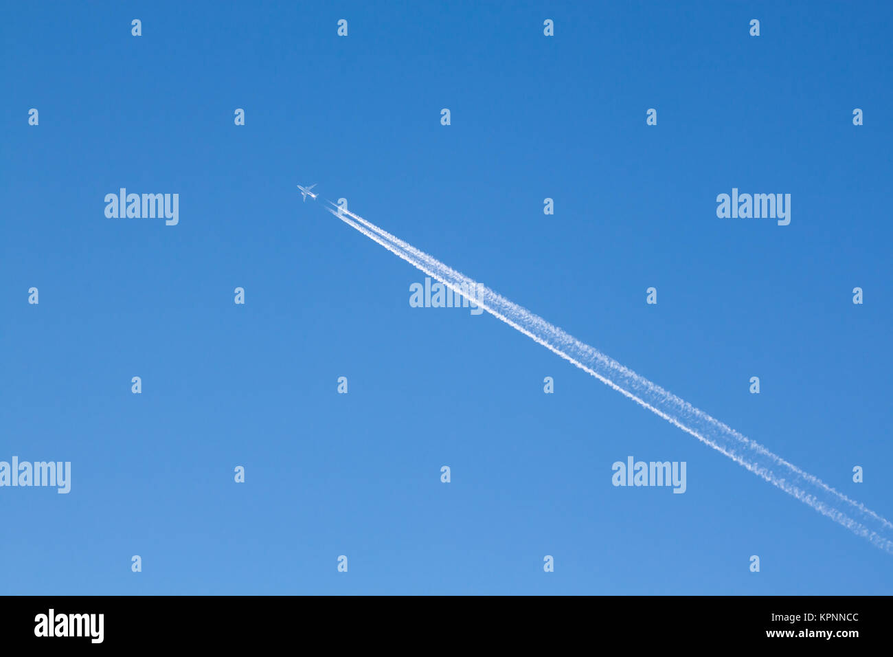 Fernweh - GroÃŸes Passagierflugzeug mit Kondensstreifen am blauen Himmel Stock Photo