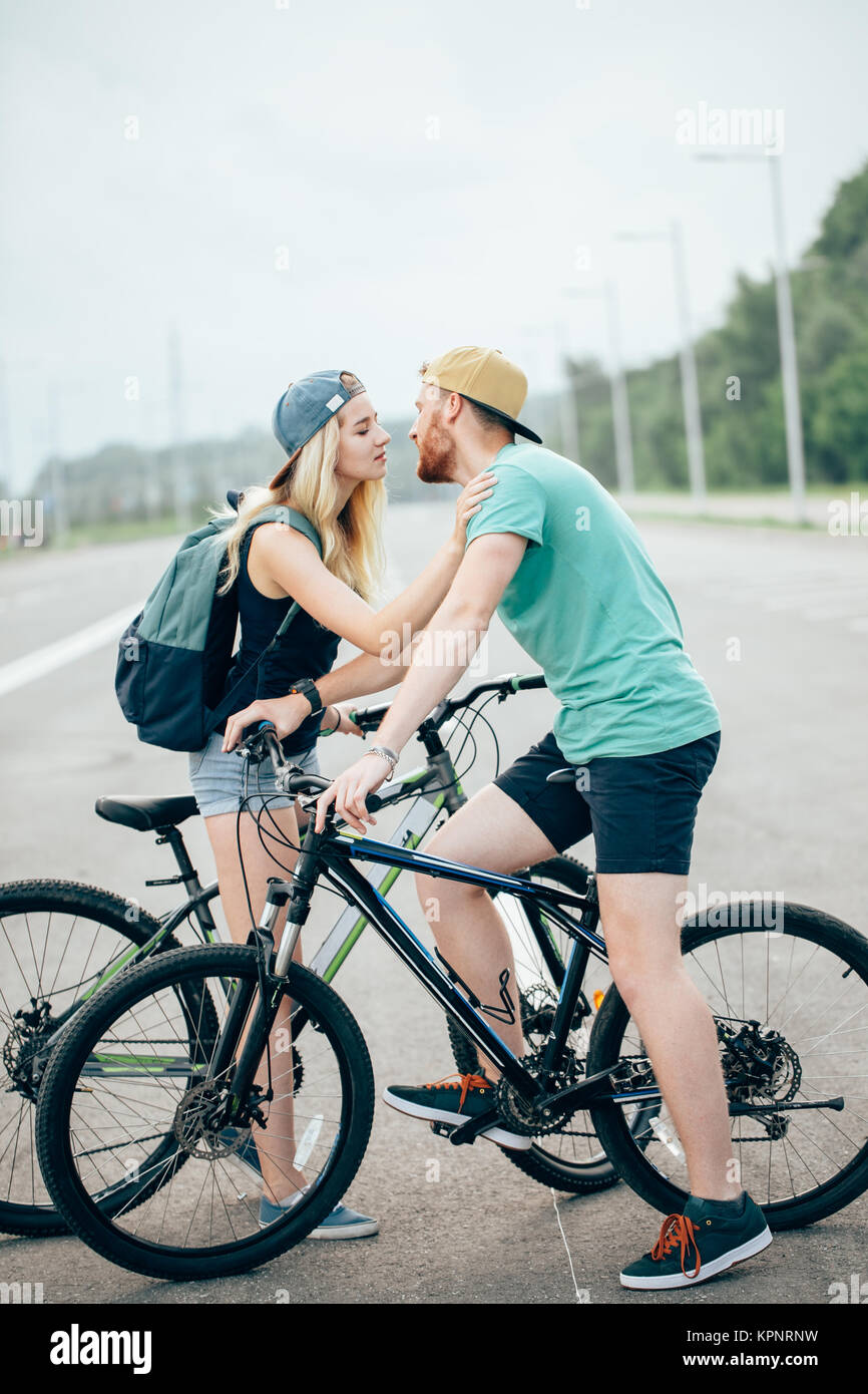Romantic sports couple kissing against blurred background with bicycles