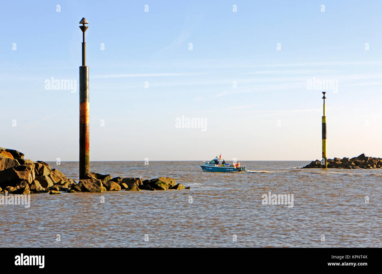 A view of an inshore fishing boat heading out to sea between artificial reefs at Sea Palling, Norfolk, England, United Kingdom. Stock Photo