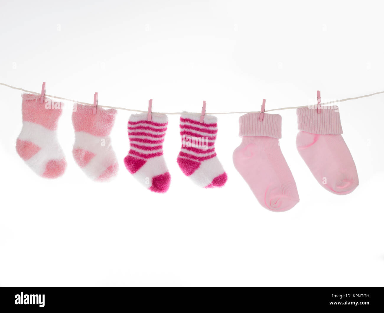Pink and white baby socks on clothesline, isolated Stock Photo Alamy