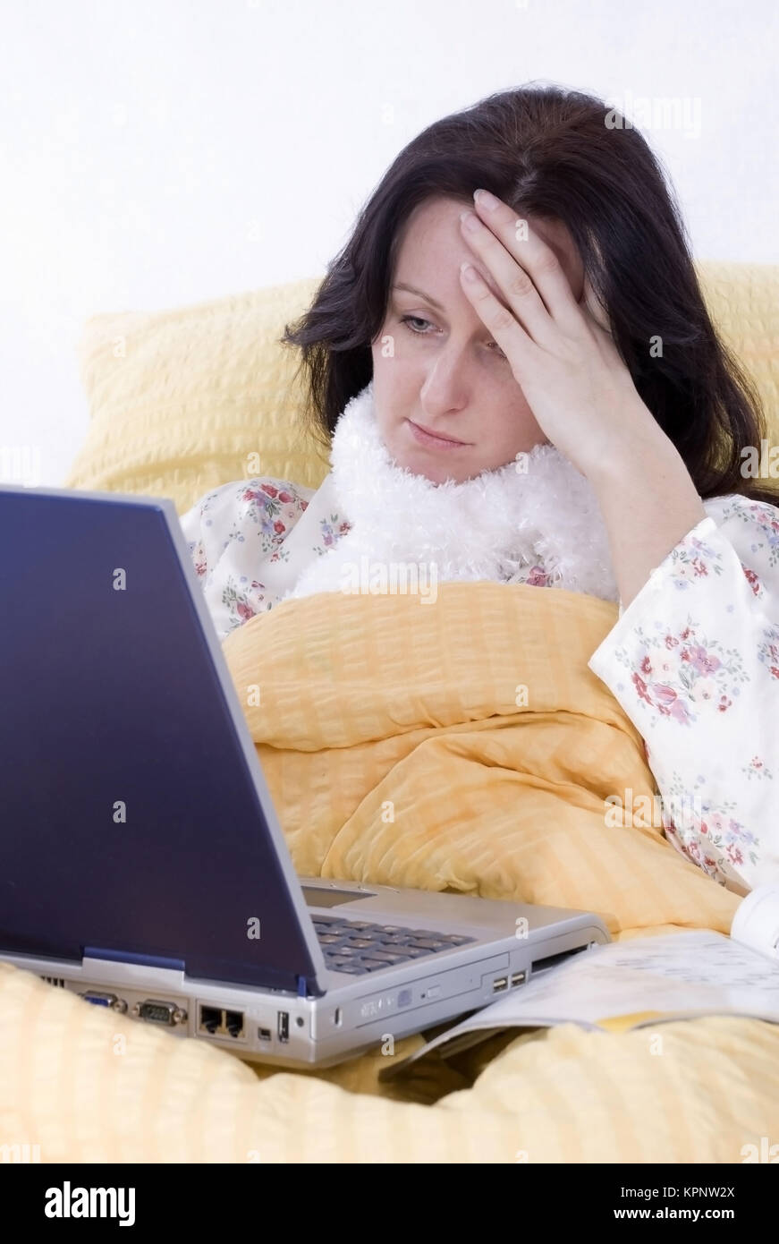 Model release , Krabke, junge Frau liegt mit Laptop im Bett - sick, young woman with laptop in bed Stock Photo