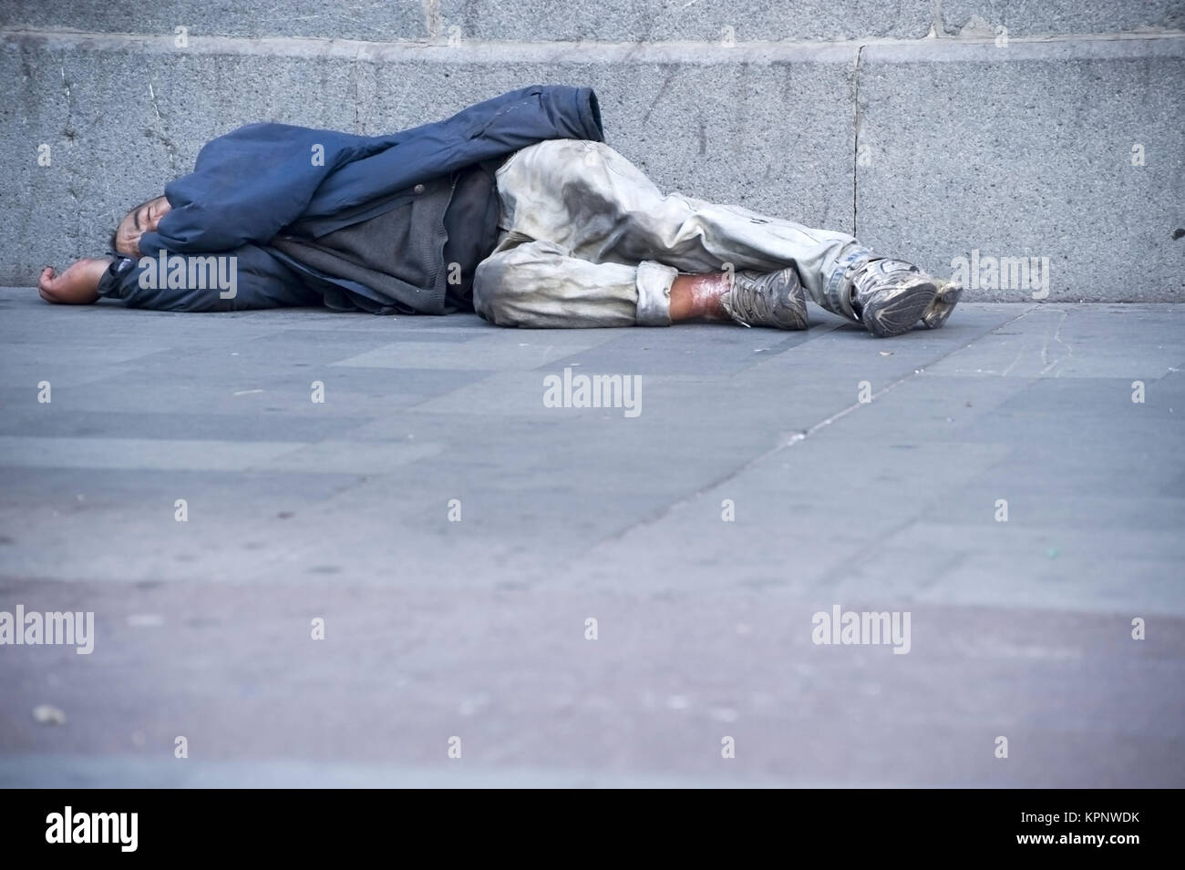 Obdachloser liegt am Gehsteig - street person Stock Photo