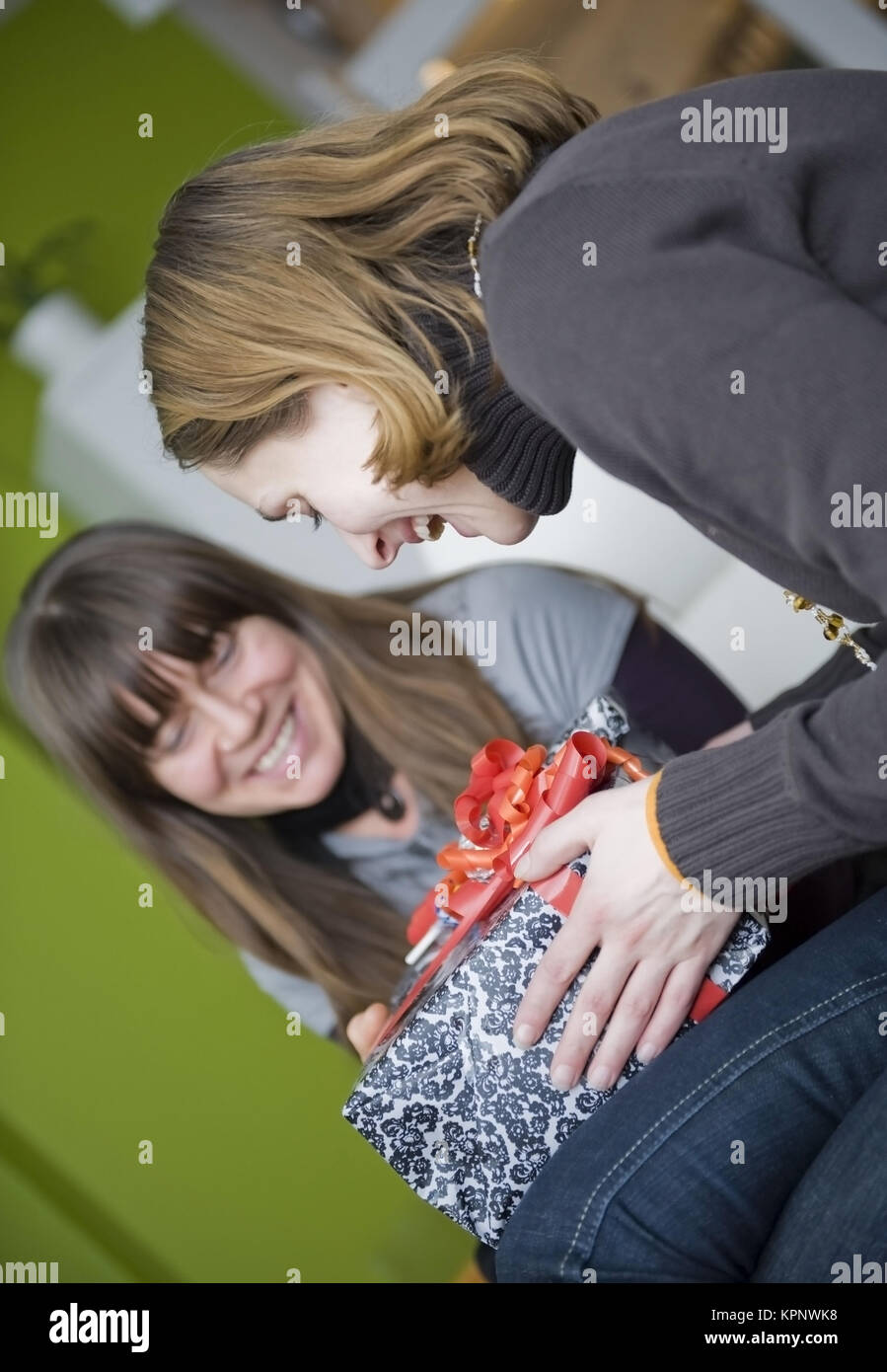 Model release , Zwei Freundinnen beim Geschenk auspacken - girl friends with present Stock Photo