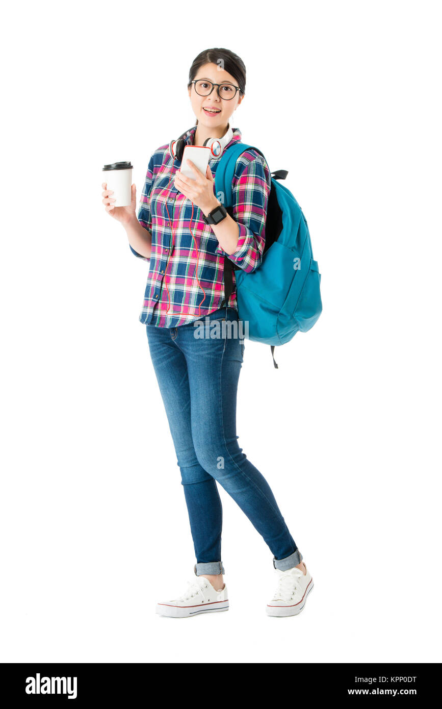 confident elegant college student holding mobile smartphone looking at camera and carrying luggage ready back to school isolated on white background. Stock Photo