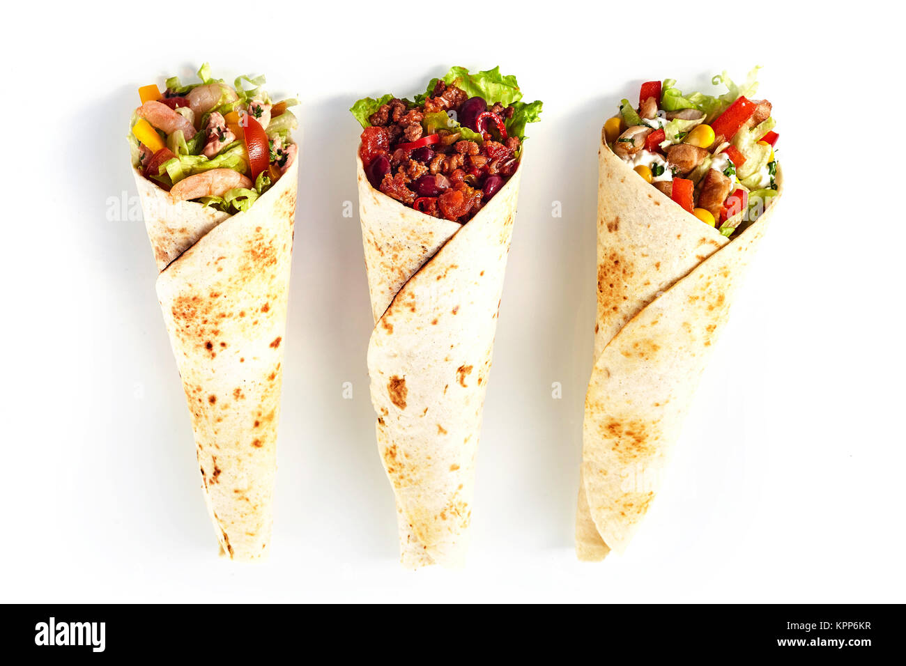 High Angle Still Life of Trio of Tex Mex Fajita Wraps Wrapped in Grilled Flour Tortillas and Filled with Variety of Fillings Such as Chicken, Chili and Shrimp and Fresh Vegetables on White Background Stock Photo