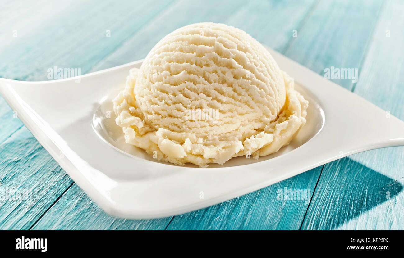 Serving of delicious frozen creamy vanilla ice cream on a modern rectangular plate outdoors on a blue rustic picnic table for summer dessert Stock Photo Alamy
