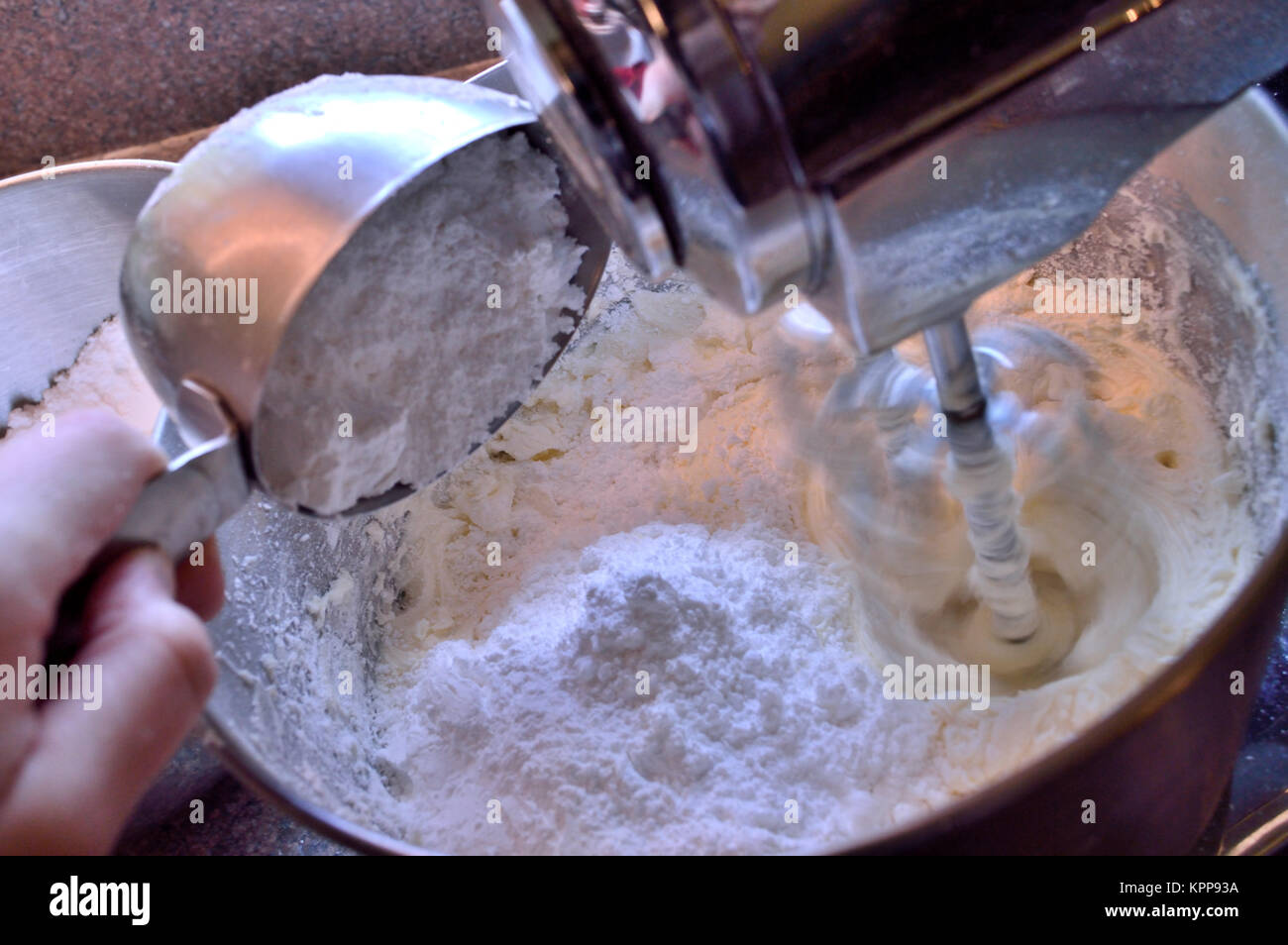 Pouring powdered sugar into frosting mixture Stock Photo Alamy